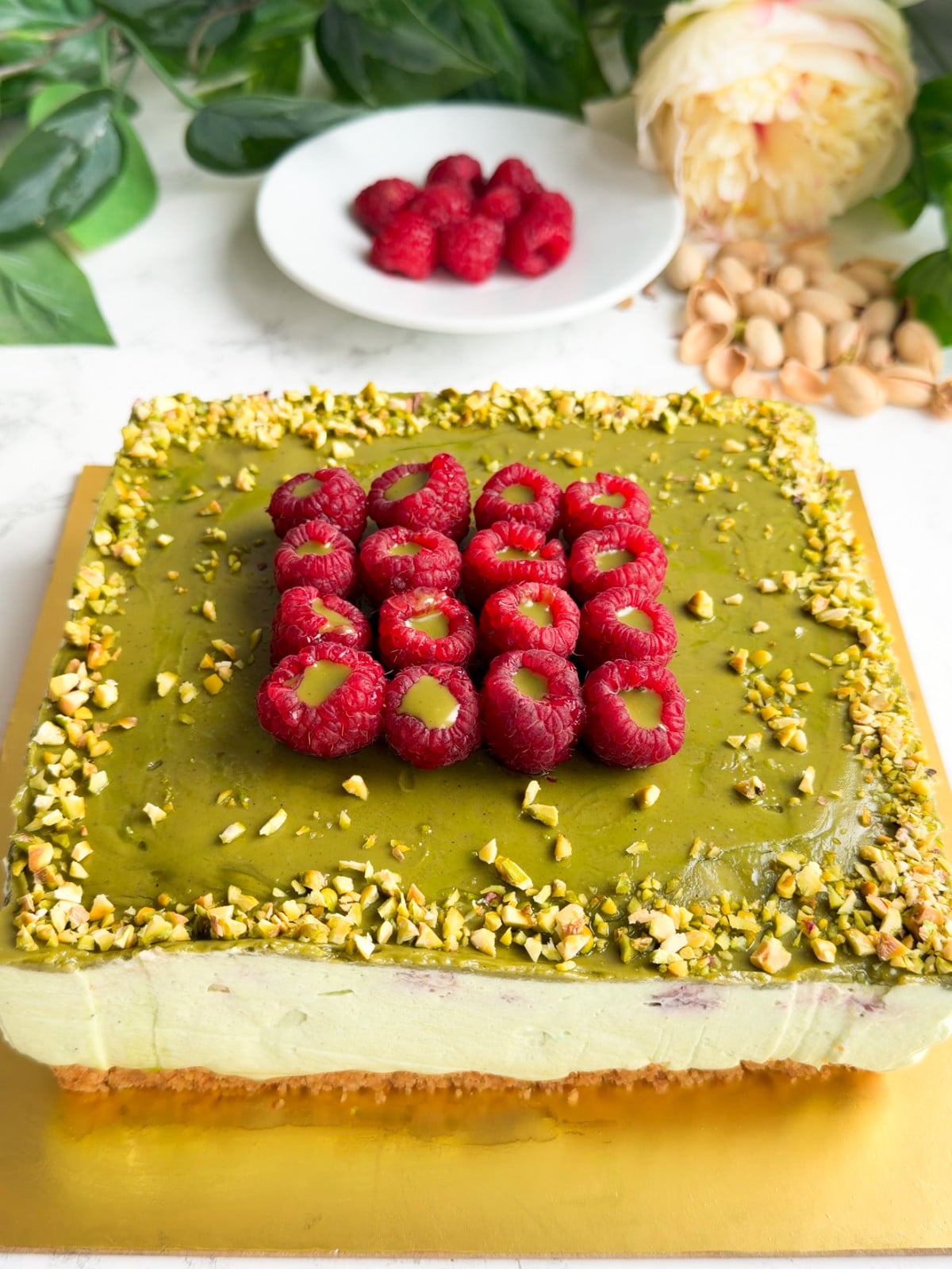 Raspberries pistachio cheesecake and crushed pistachios.