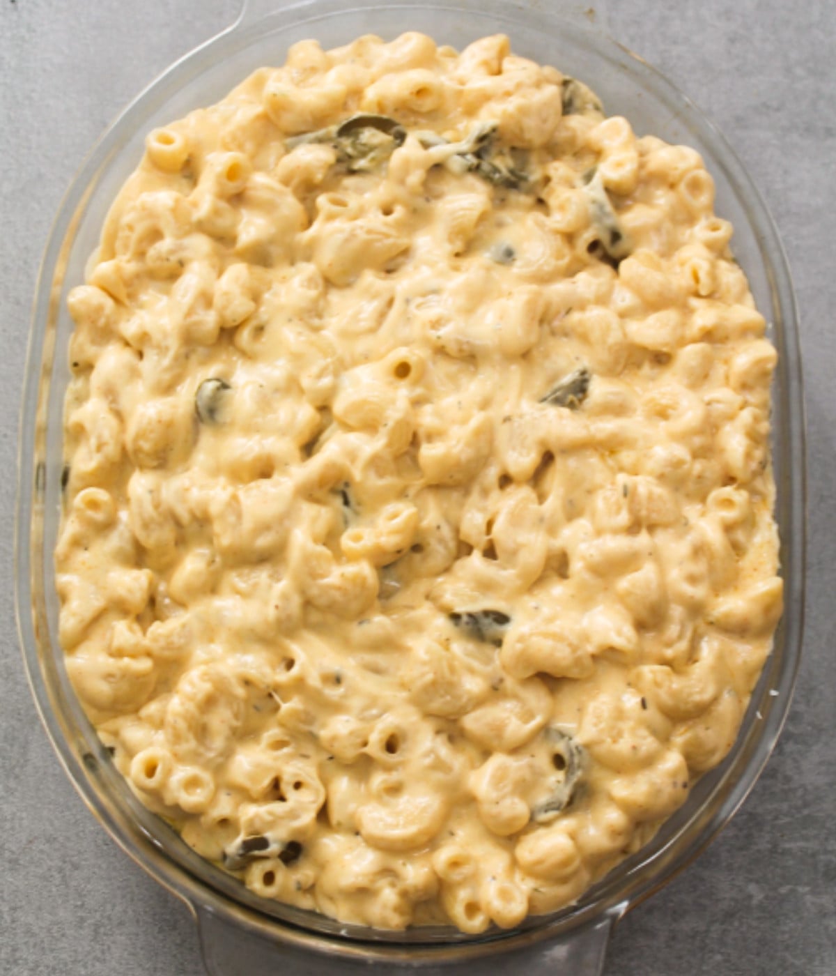 Jalapeno macaroni in a cheesy sauce in an oval oven dish.