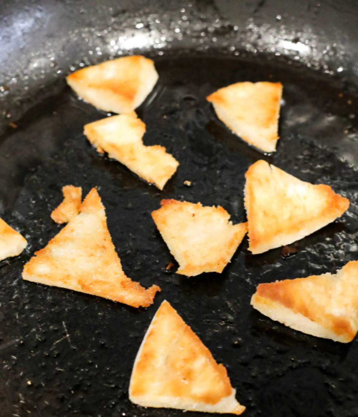 Fried pita bread in a black pan.