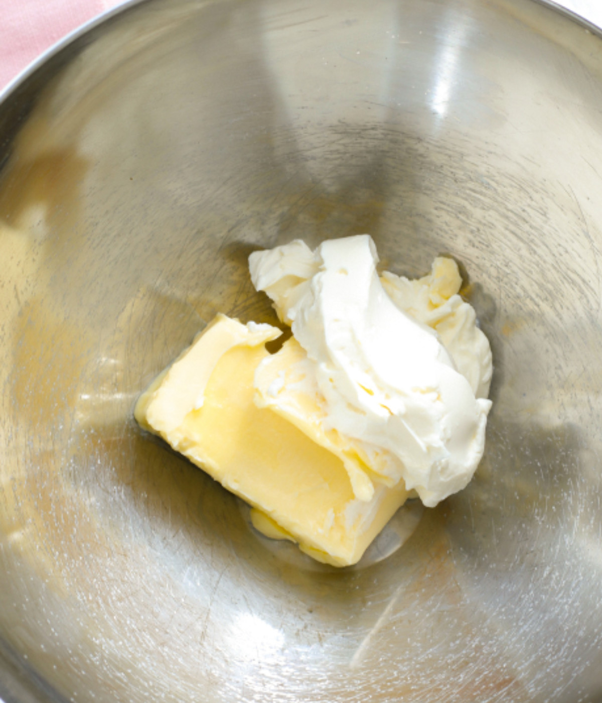 Butter and cream cheese in a silver bowl.