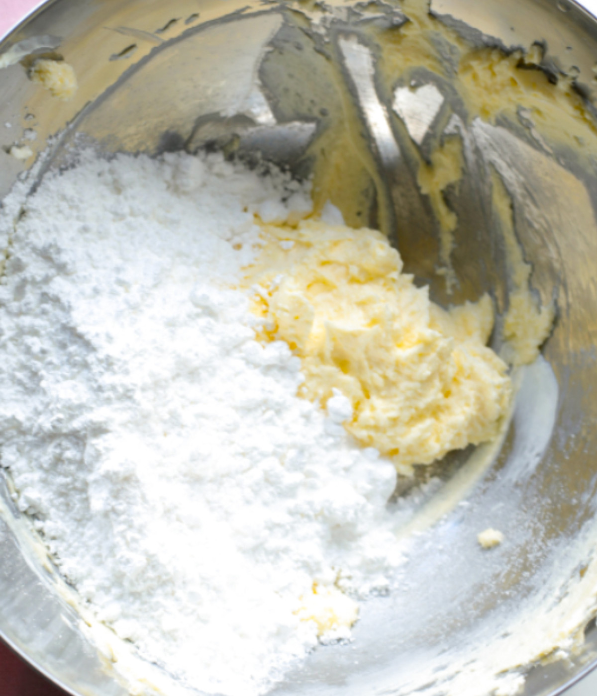 Butter, cream cheese and icing sugar in a silver bowl.