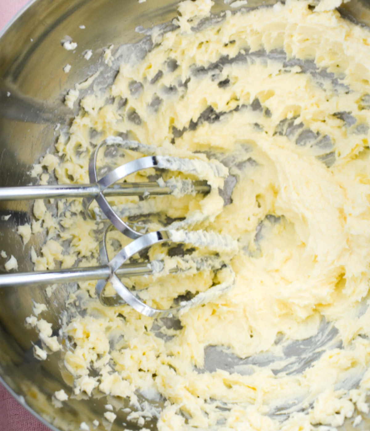 Whisked butter and cream cheese in a silver bowl.