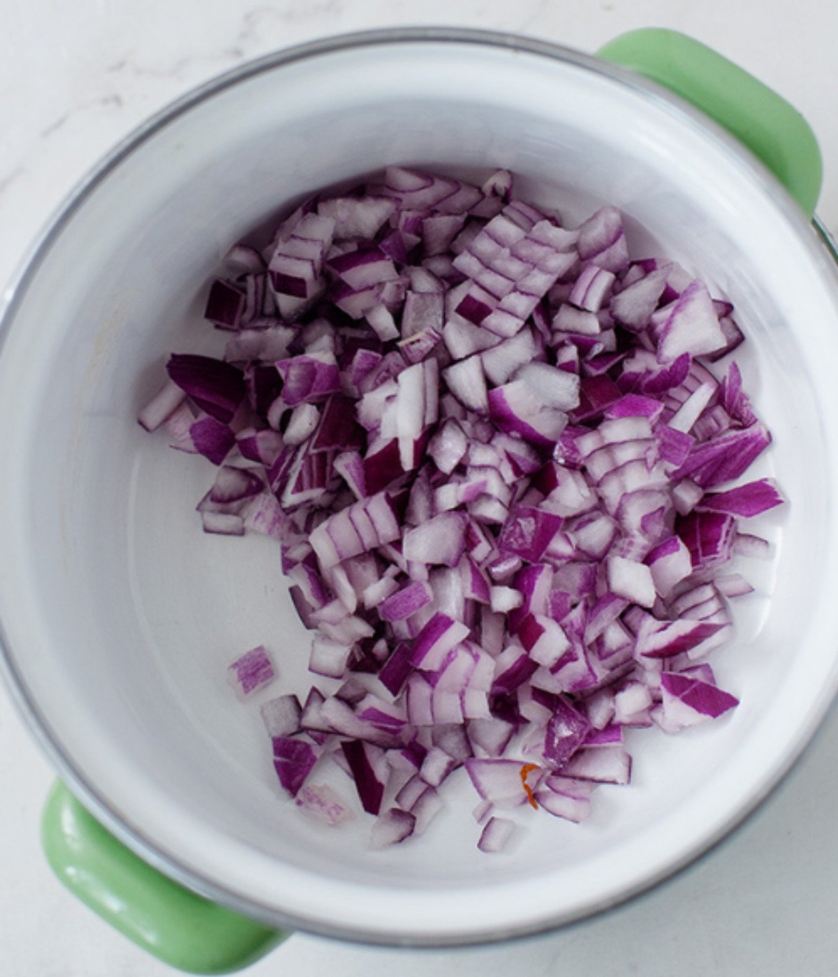 Chopped red onions in a white pot.