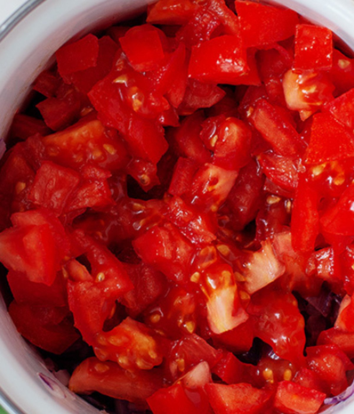 Chopped tomatoes in a white pot.