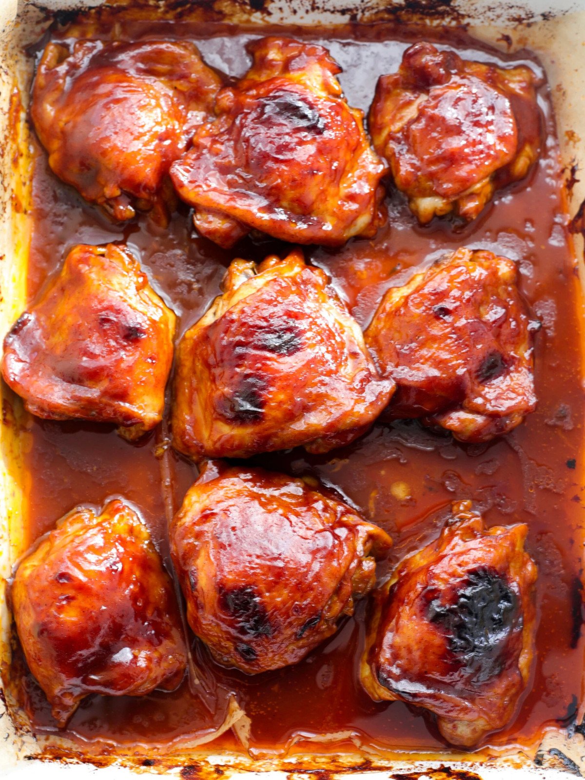 Sticky barbecue flavor chicken thigh in an oven dish.