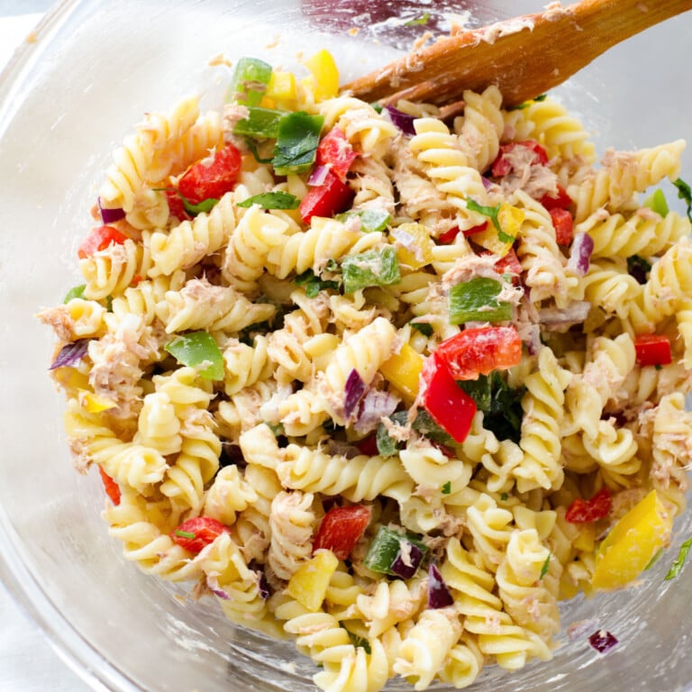 Tuna fusilli in a glass bowl with a wooden fork.