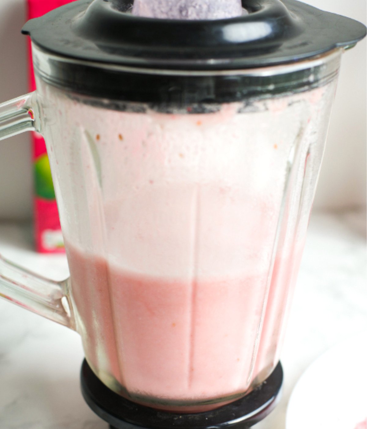 Frozen raspberries, coconut cream, ice and pink glitter mixed in a mixer.