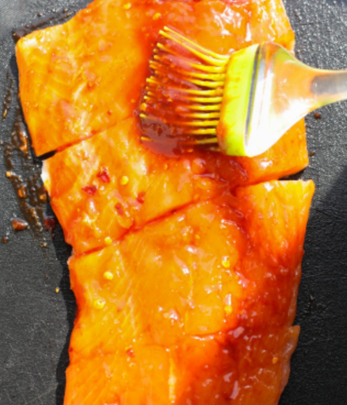 Uncooked salmon basted with spicy marinade.