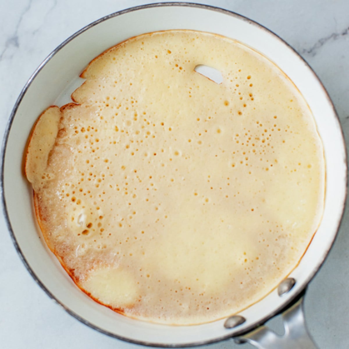 African pancake batter in a white pan.