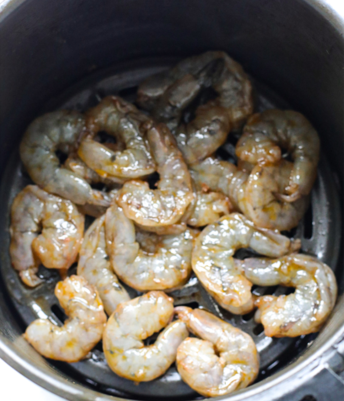 Seasoned shrimp in an air fryer.