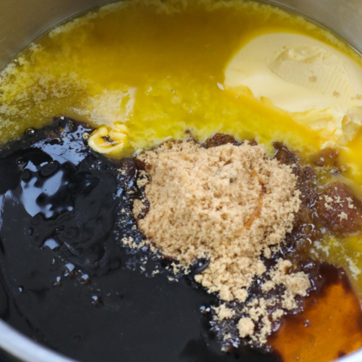 Melted butter, brown sugar, black treacle and golden syrup in a pot.