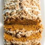 pumpkin bread with crumb topping and maple glaze on top.