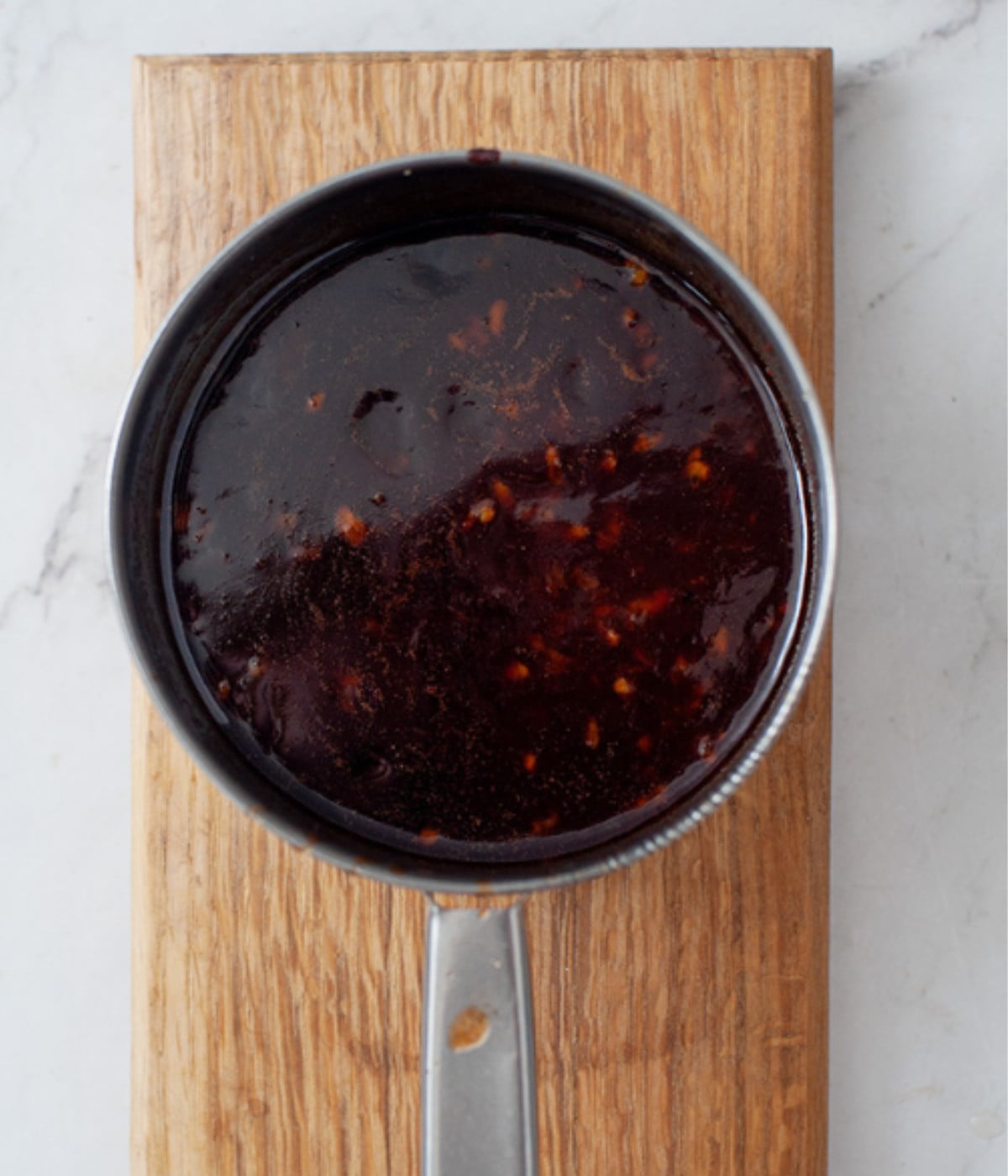 Cooked unsalted butter, sriracha sauce, honey, vinegar, soy sauce, garlic and lemon juice in a pot.