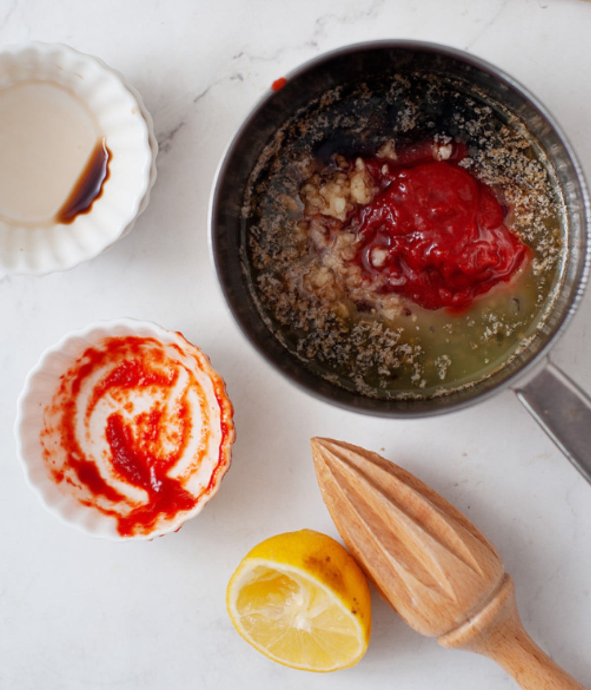 Unsalted butter, sriracha sauce, honey, vinegar, soy sauce, garlic and lemon juice in a pot.
