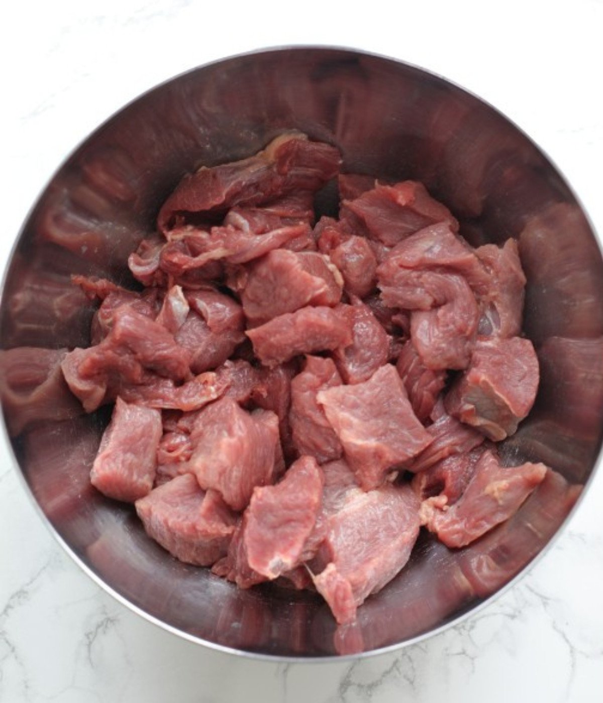Chopped beef in a silver bowl.
