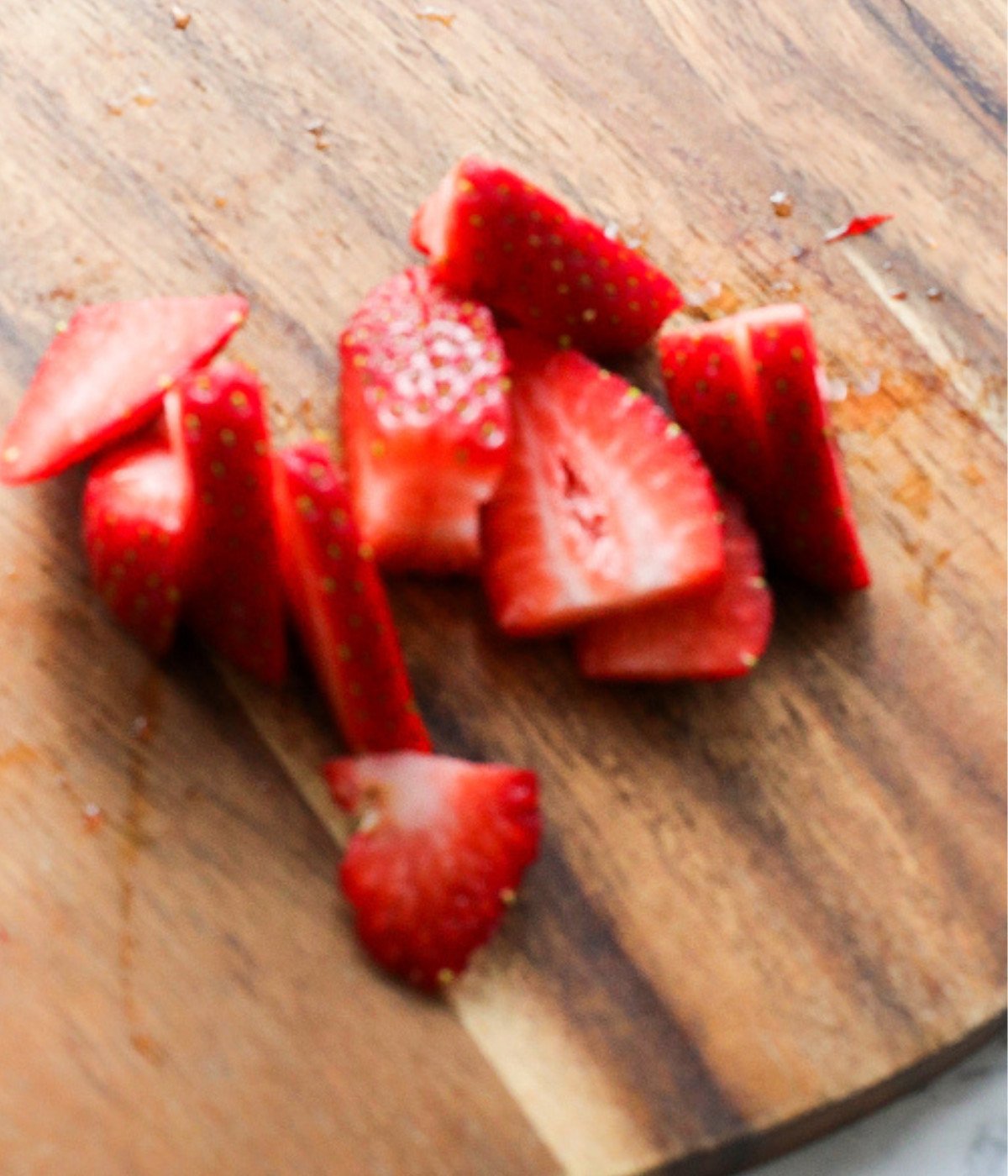 Fresh strawberries on a wooden chopping board.