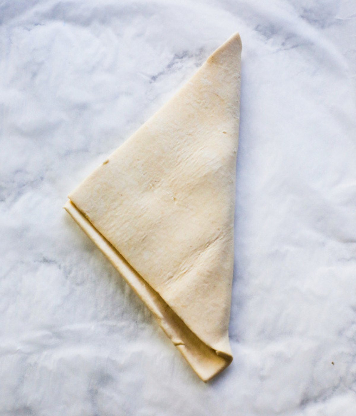 Square puff pastry sheet folded into a triangle.