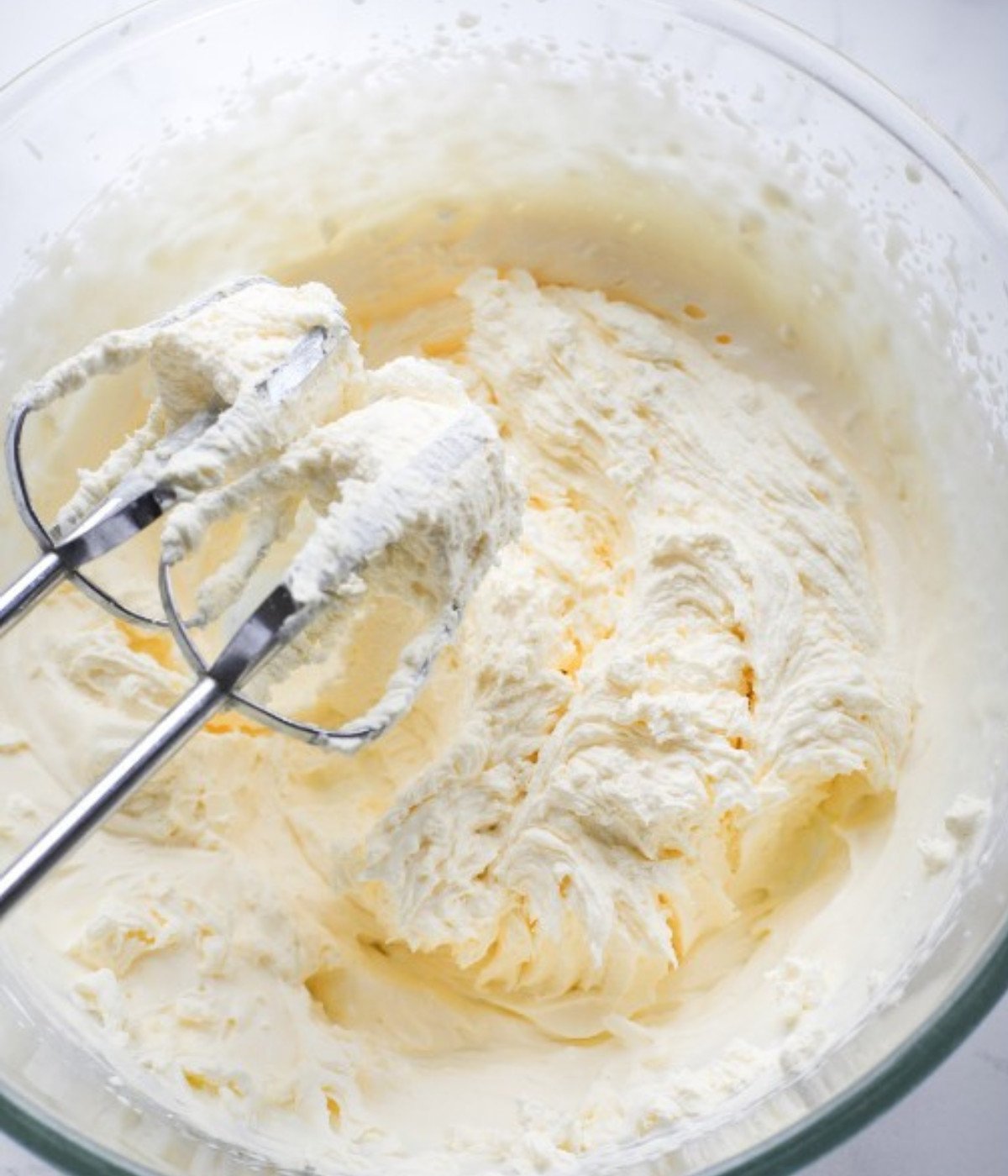 Heavy cream and sugar in a glass bowl.