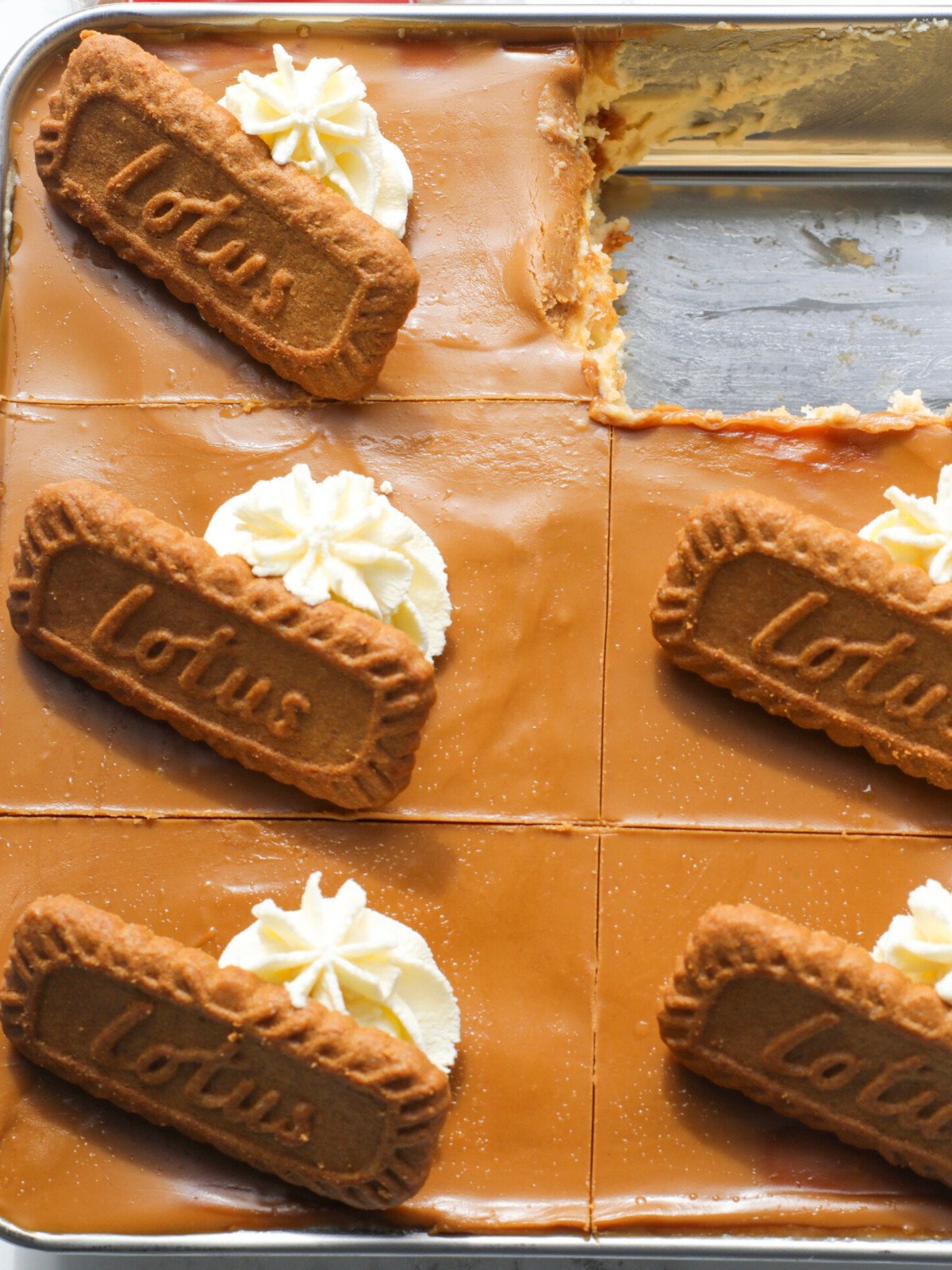 Lotus biscoff tiramisu with whipped cream in a silver sqaure tin.