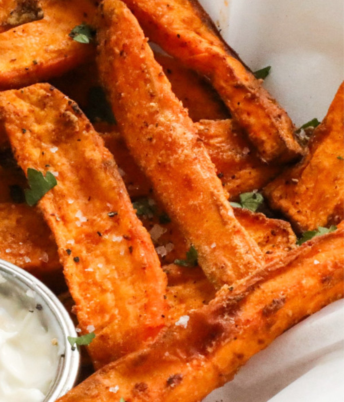 Seasoned air fried sweet potatoes wedges topped with parsley.