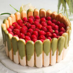 Tiramisu with pistachios dessert topped with raspberries.