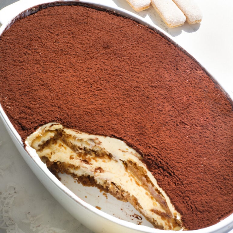The best Italian tiramisu in a white oval dish on a table.