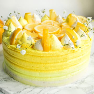 Lemon ombre cake decorated with lemon slices and baby's breath flowers.