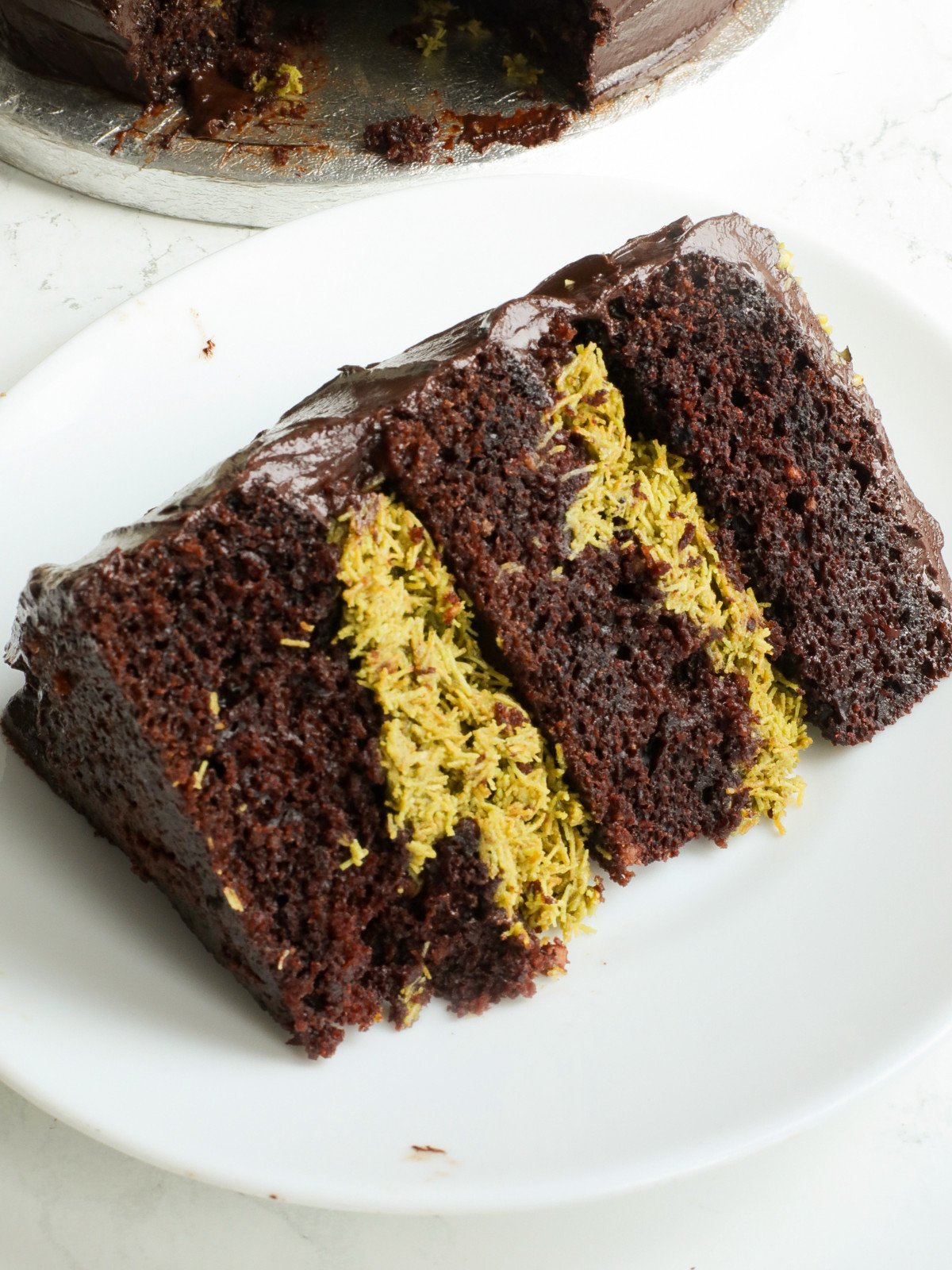 A slice of dubai cake on a white plate.