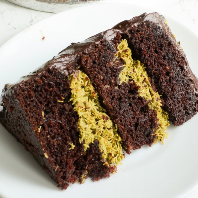 A slice of three layer Dubai cake on a white plate.