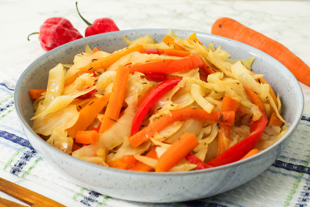 Jamaican cabbage, carrots and red bell peppers in a bowl.