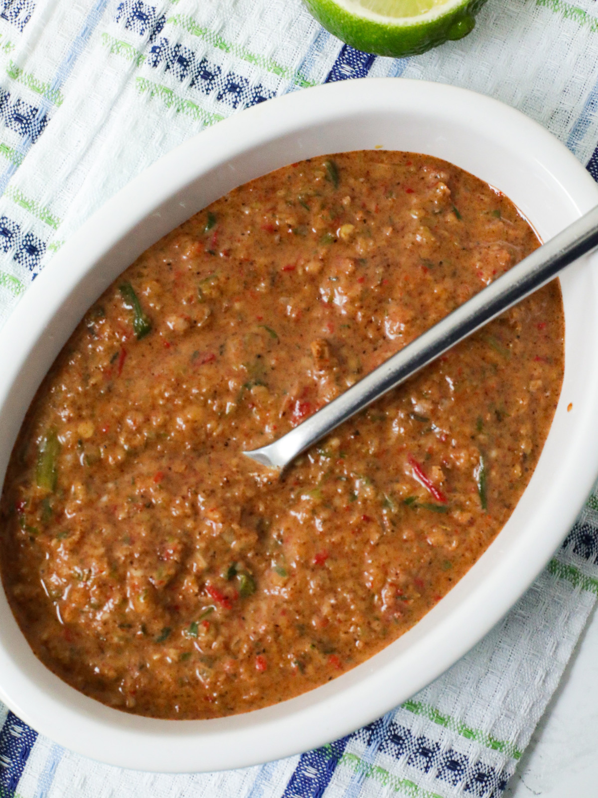 Jerk marinades sauce in an oval bowl with a spoon.