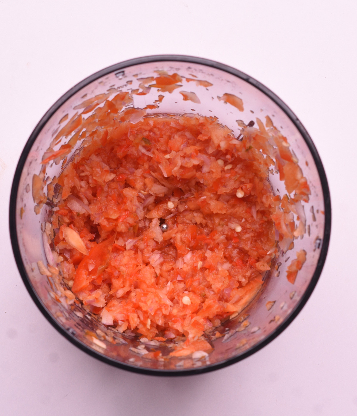 Blended red onions, red bell peppers and scotch bonnets in a blender.