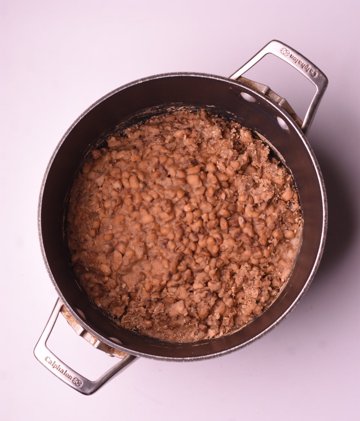 Brown beans cooked in a pot of water and mashed.