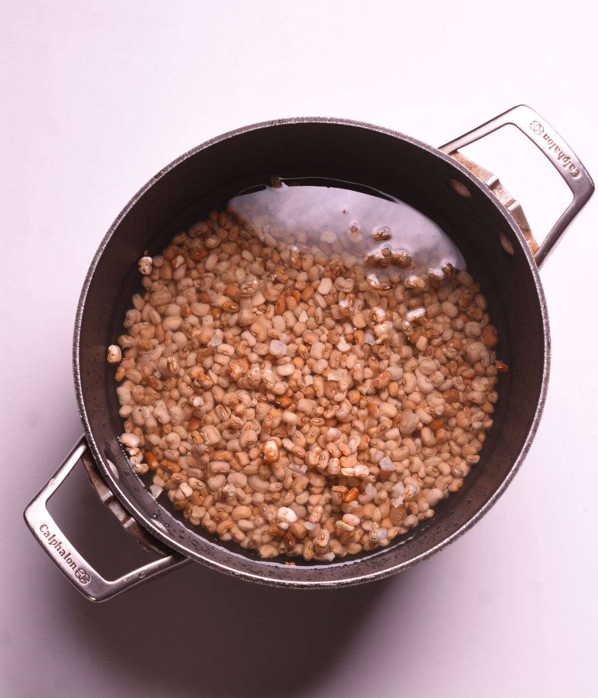 Brown beans in a pot of water.
