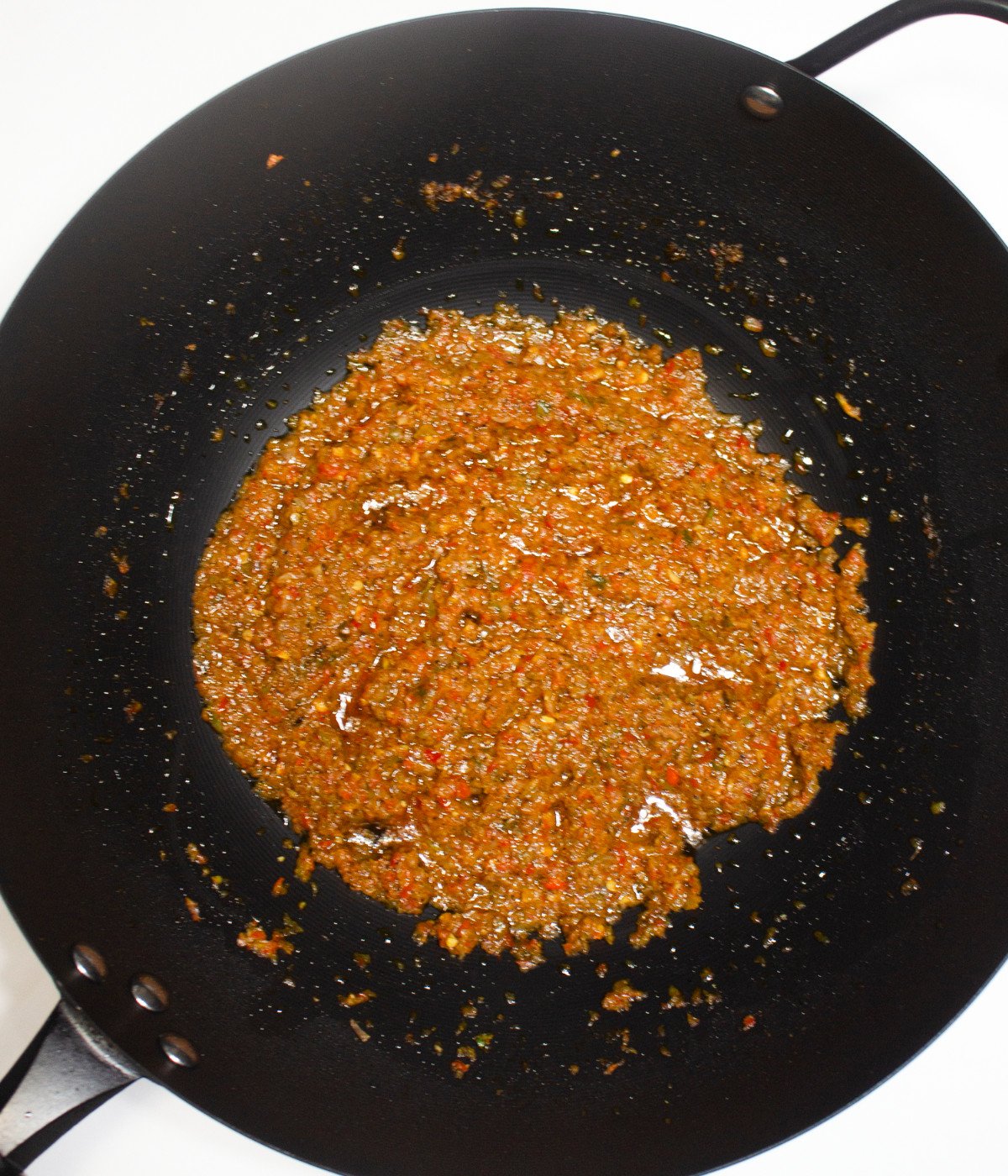 Hot oil and blended pepper mic in a black pan.