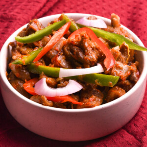 Nigerian peppered goat meat in a white bowl.