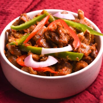 Nigerian peppered goat meat in a white bowl.
