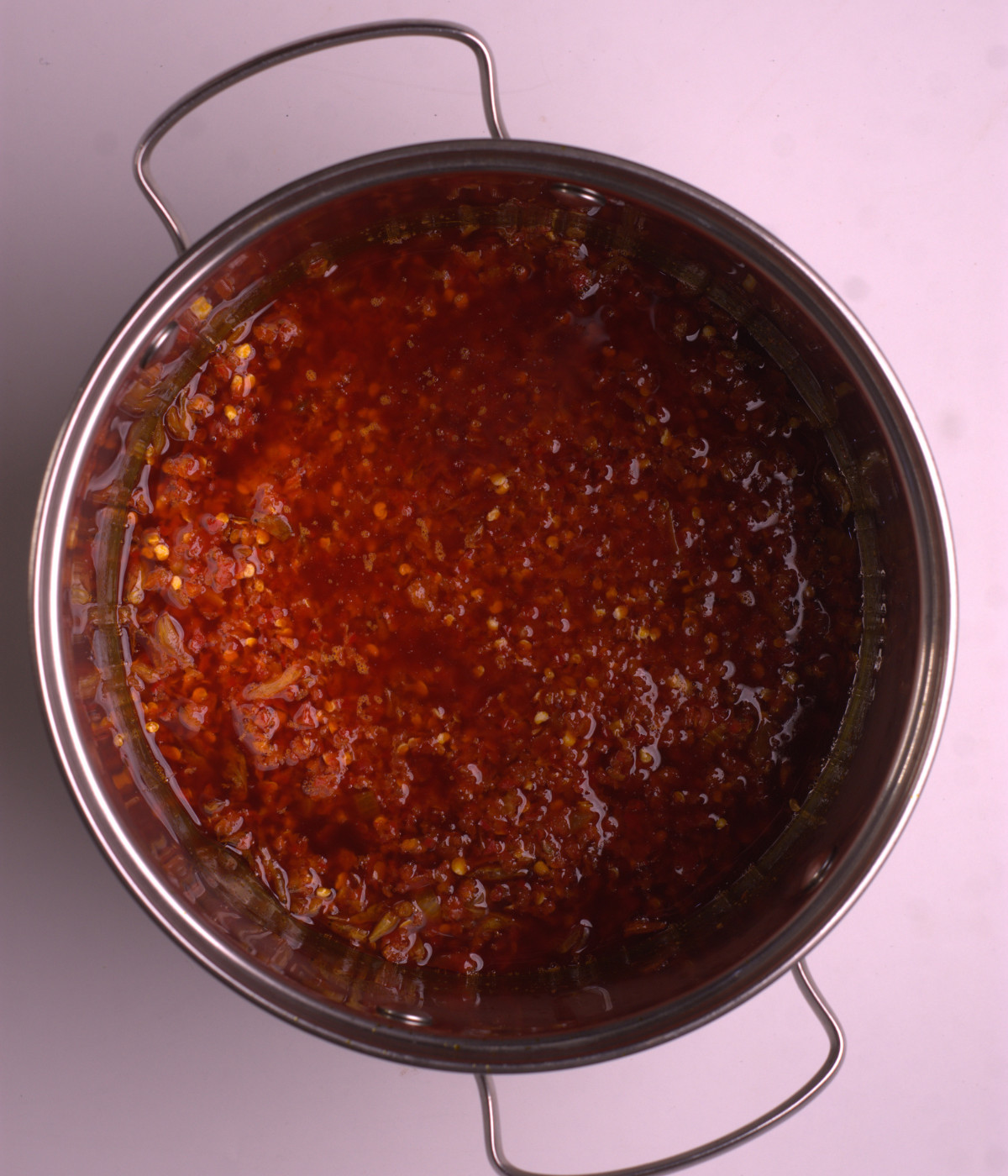 Palm oil, blended pepper and onion cooked in a silver pot.