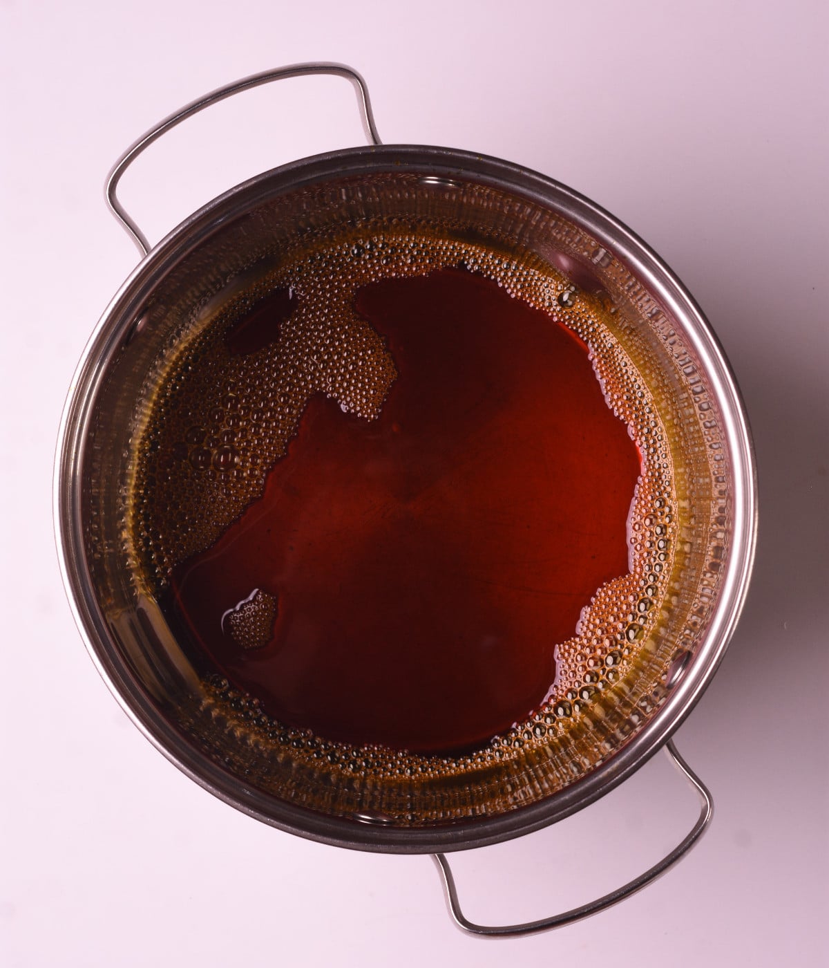 Palm oil heated in a silver pot.