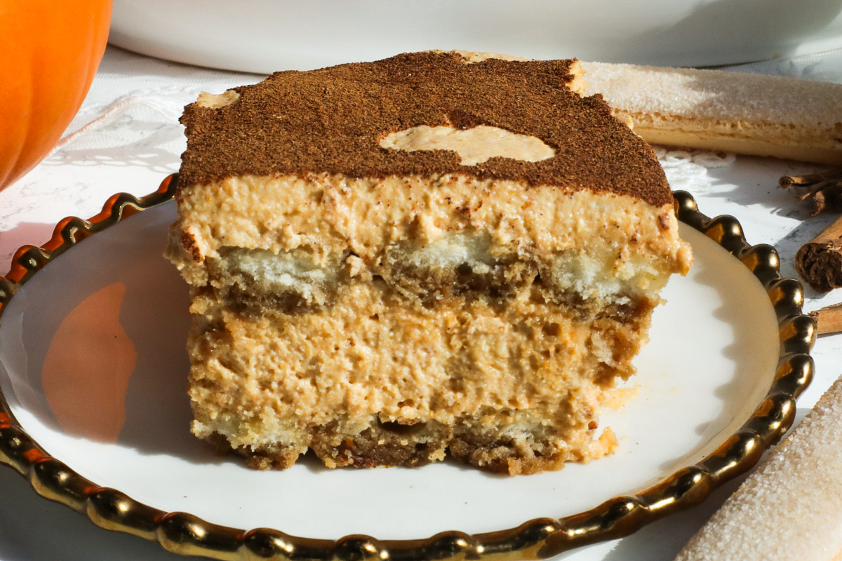 A slice of pumpkin tiramisu on a white and gold plate.