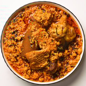 Egusi, tripe, cowfoot,and meat in a white bowl.