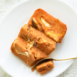 Moi moi cut in three pieces on a white plate with a gold fork.