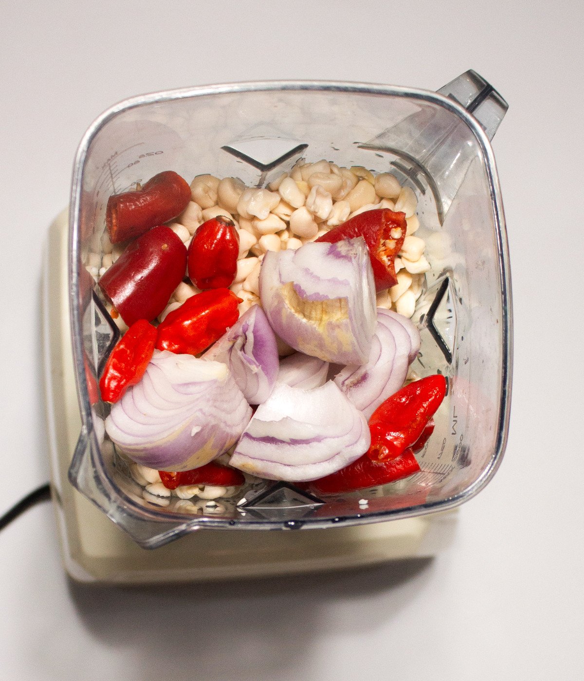 Peeled beans, onion, red bell pepper, scotch bonnets in a blender.