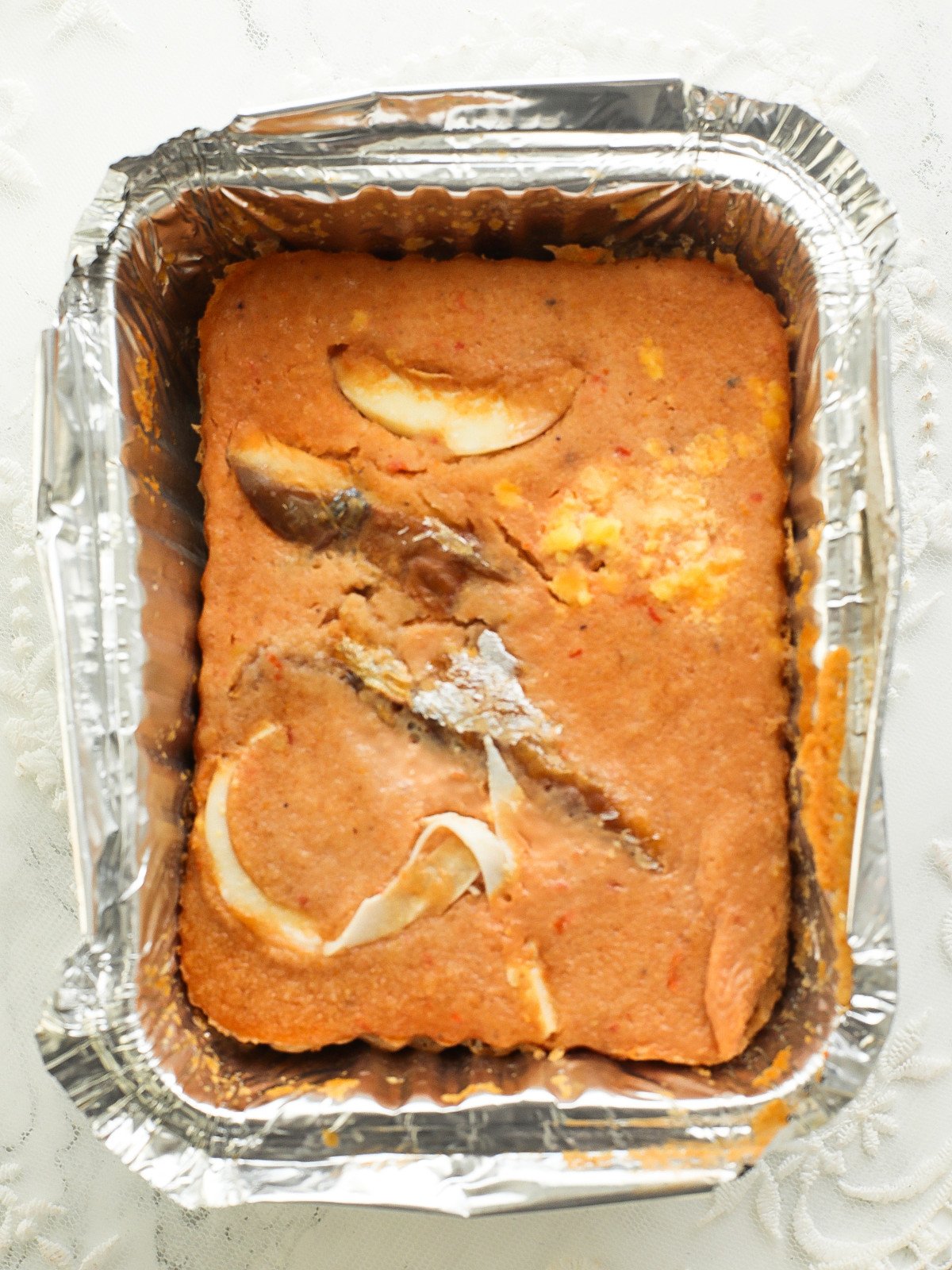 Steamed moi moi with smoked fish and egg in a foil pack.