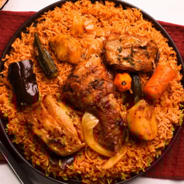 Senegalese jollof in a black plate on a red cloth.
