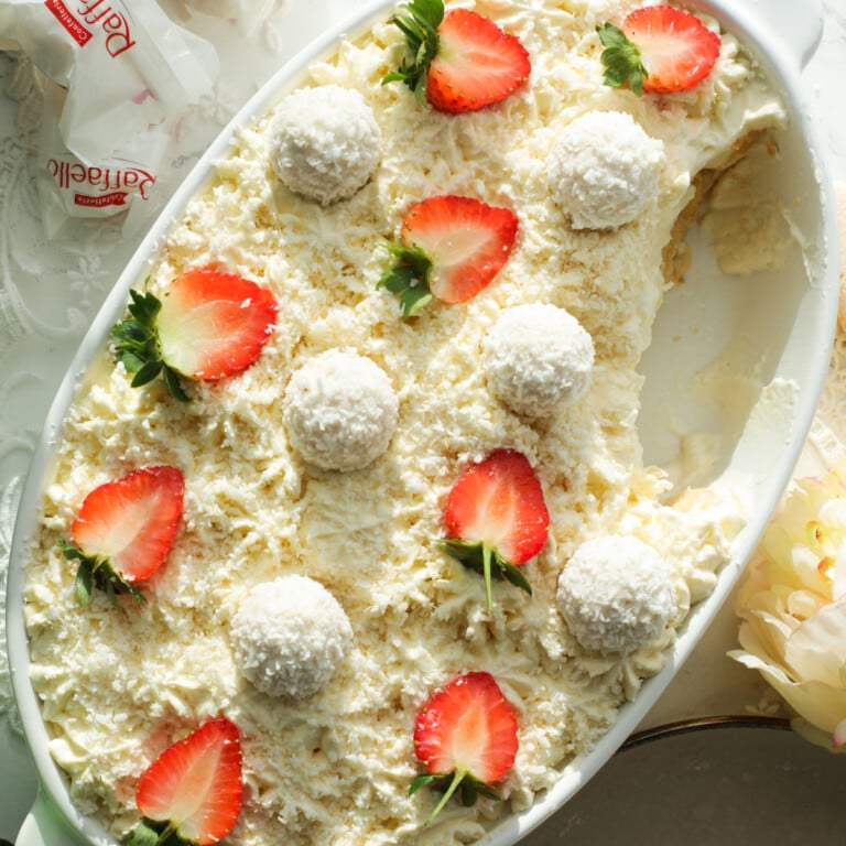 Coconut Raffaellos Tiramisu in a white oval dish with strawberries..