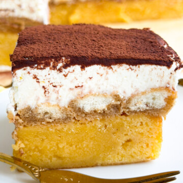 Tiramisu blondie on a plate and a gold fork.