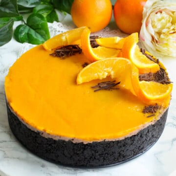 Oranges and chocolate cheesecake with orange slices and chocolate shavings on top.