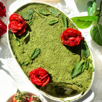 Matcha with strawberry tiramisu served in a white oval dish.