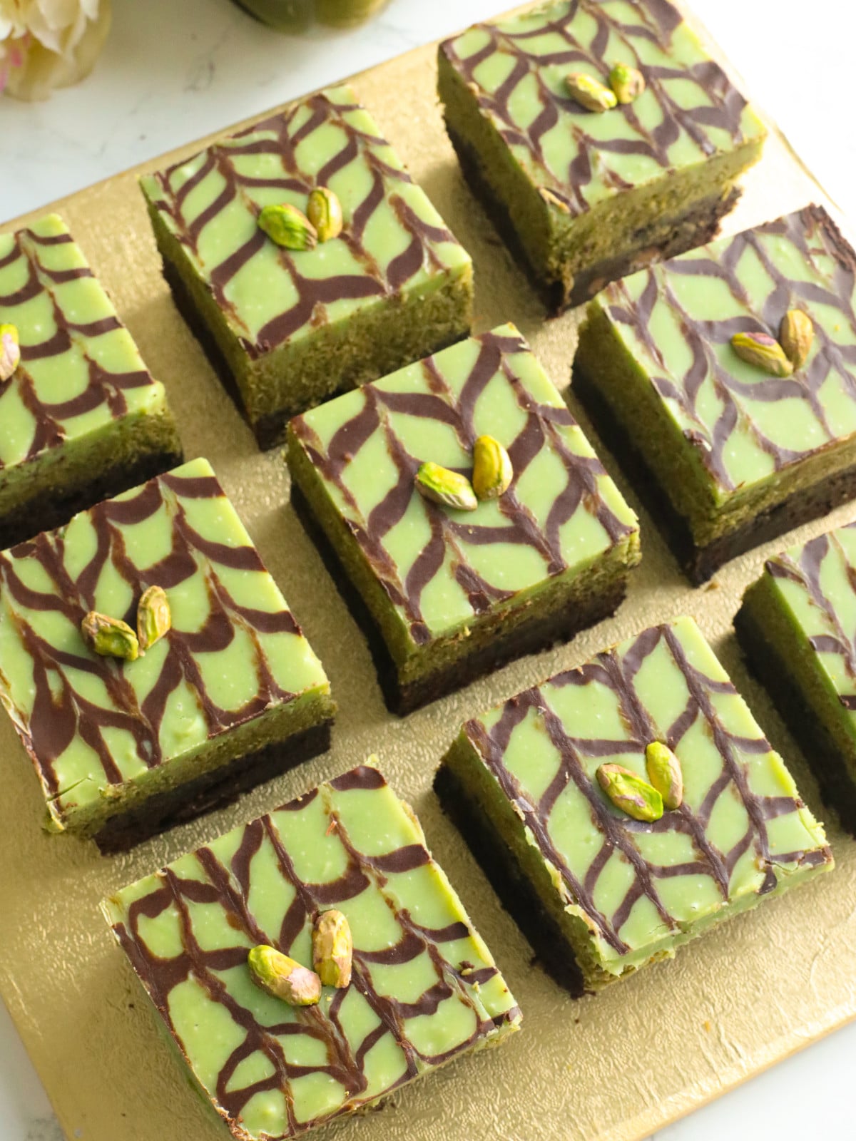 Pistachio kataifi chocolate brownies with pistachio ganache and pistachios on top.